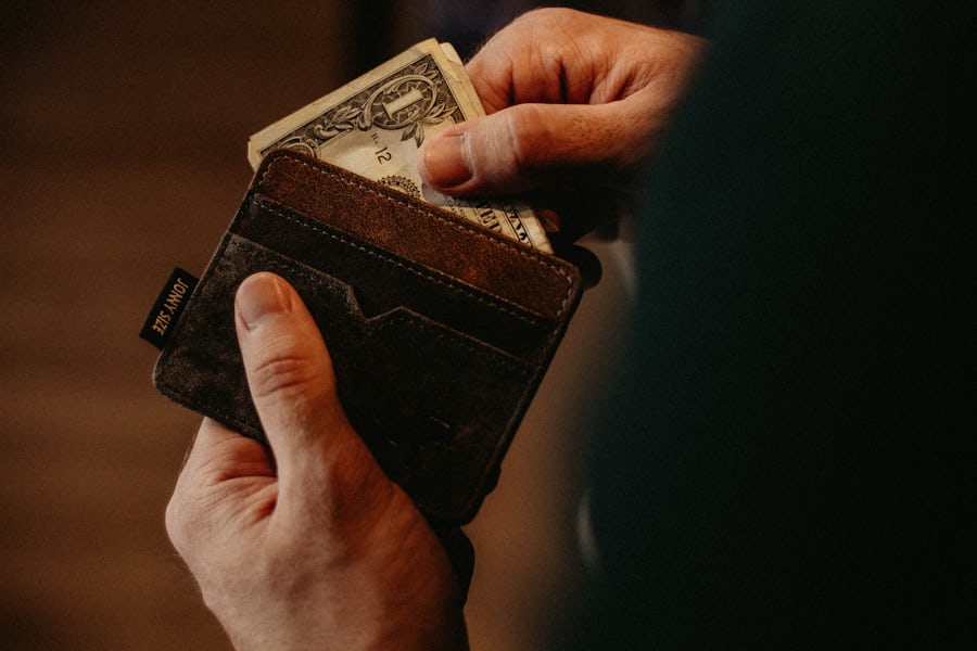 Tangan menerima uang tunai ke dalam dompet